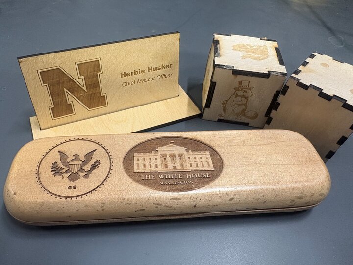 Laser cut projects including name tag, custom dice, pen box