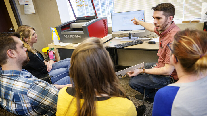 Max Wheeler (pointing to computer screen), NIS instructional designer, leads a training for Library Innovation Studios May 22.