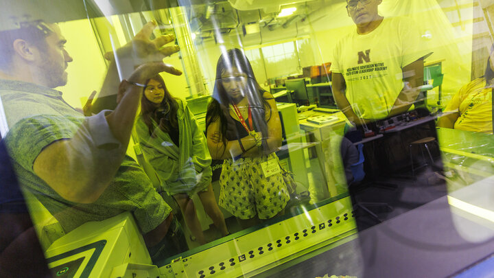 Max Wheeler (left), with Nebraska Innovation Studio, explains how the laser cutter works during the 2022 MATC/NCIA Sovereign Native Youth STEM Leadership Academy on June 30.