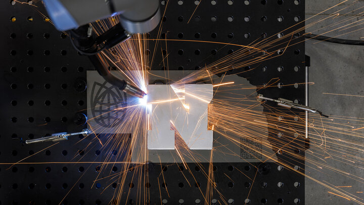 A robotic welder works around a Nebraska "N" at Nebraska Innovation Studio