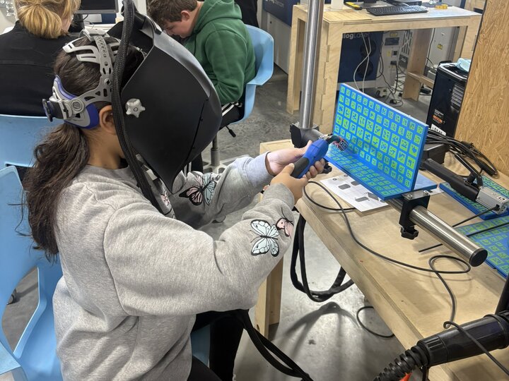 Girl wearing a augmented reality helmet creating virtual welds