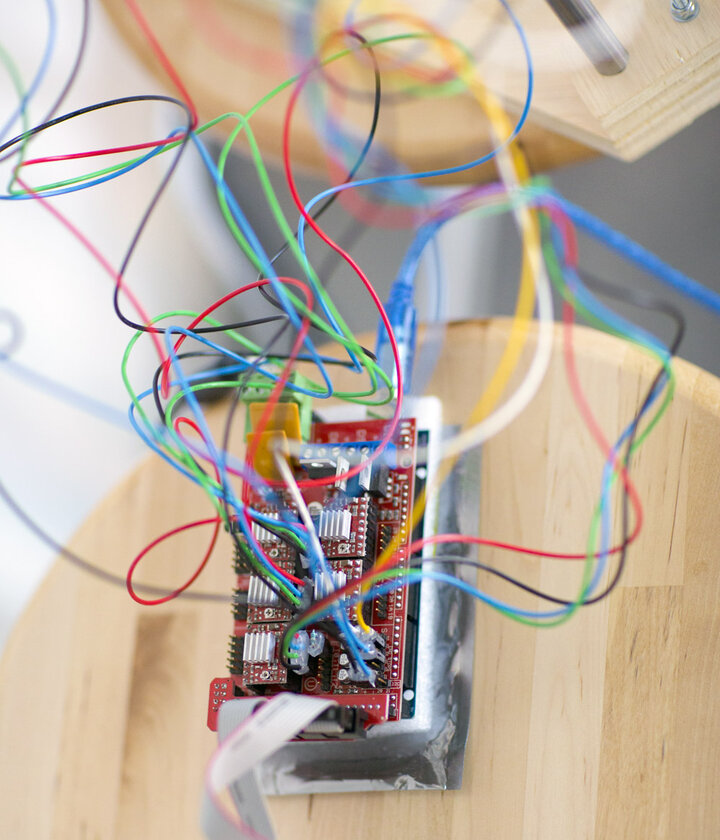 Circuit board with wires sticking out of it sitting on a table